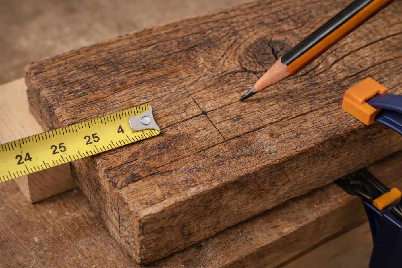 Repère précis de perçage tracé sur une planche en bois ancien