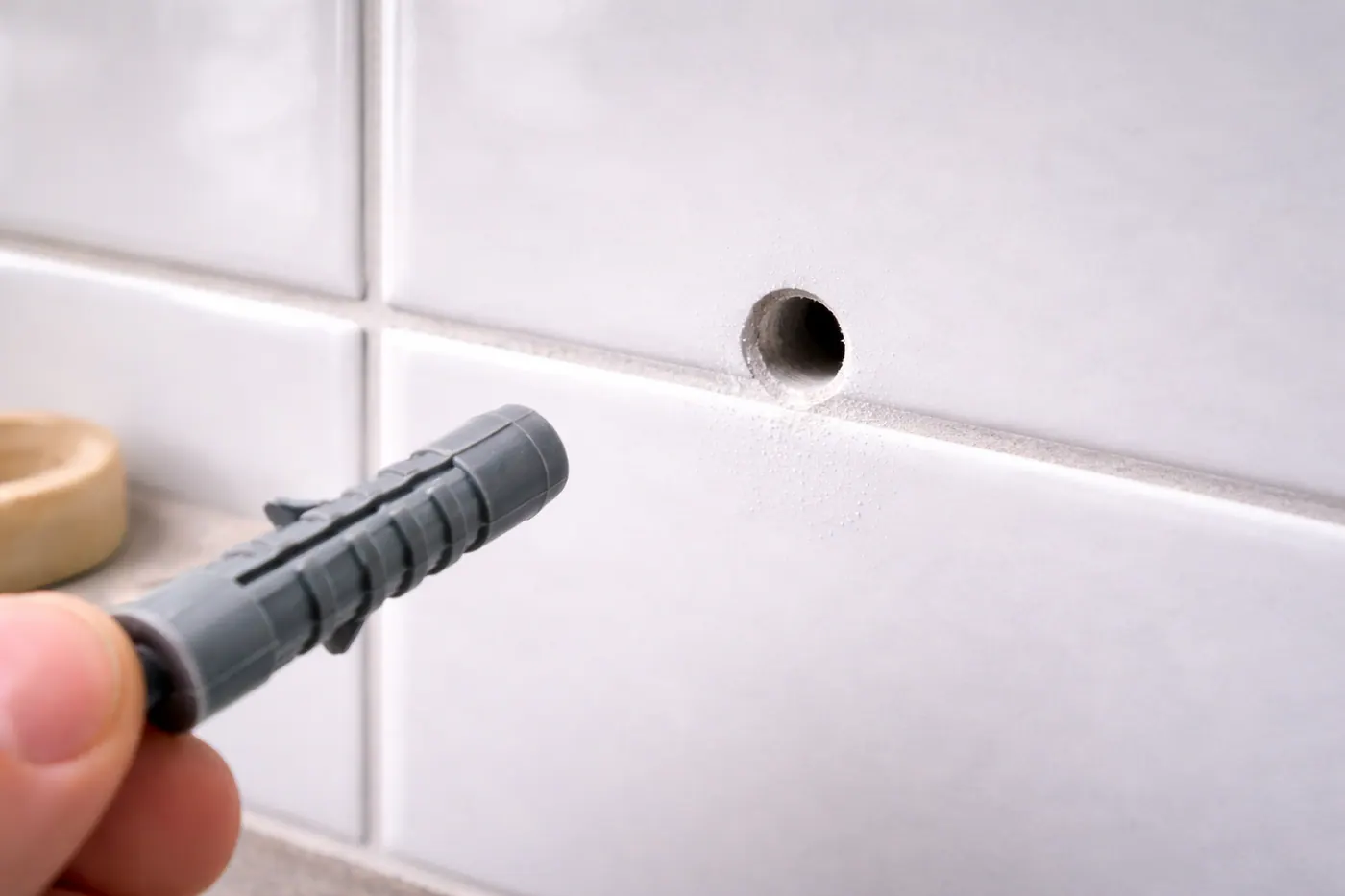 Trou propre dans carrelage mural avec cheville prête à être posée